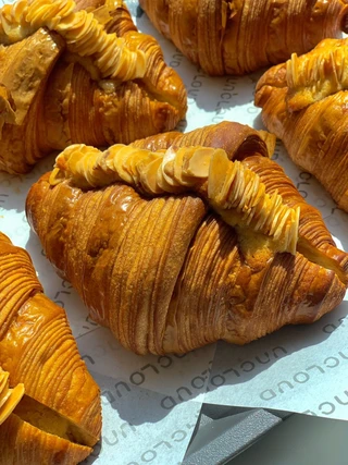 ครัวซองต์เนยสีทองมุมใกล้ Uncloud Coffee